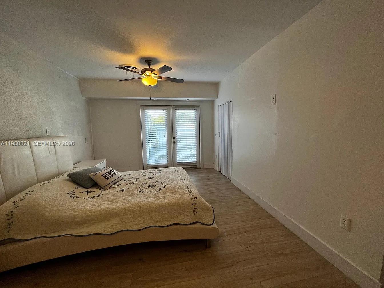 2049 Southwest 60th Court, Unit 1 Miami, FL 33155 - Photo 5 of 16 a bedroom with a bed and a chandelier