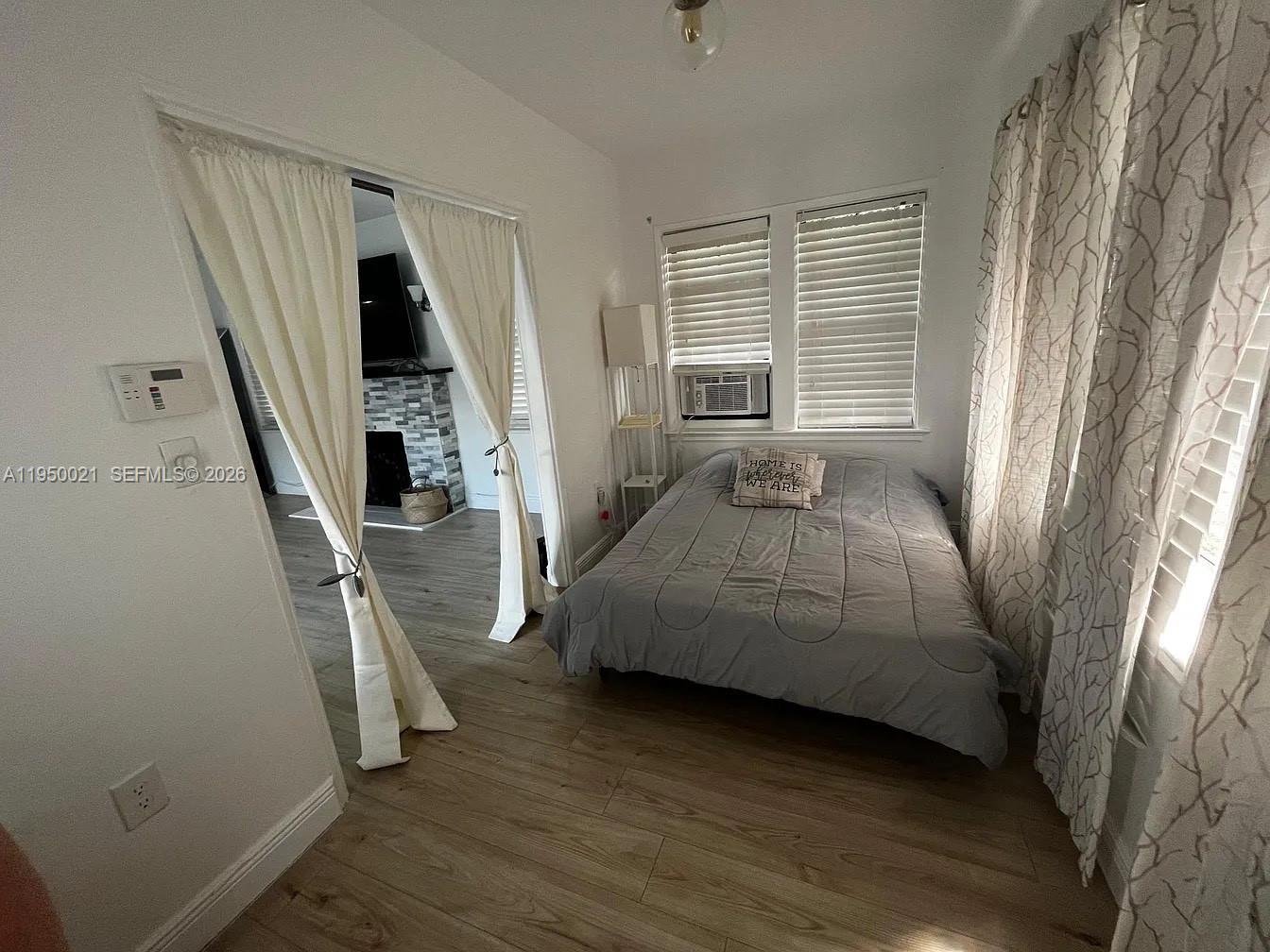 2049 Southwest 60th Court, Unit 1 Miami, FL 33155 - Photo 7 of 16 a bedroom with a bed furniture and a large window