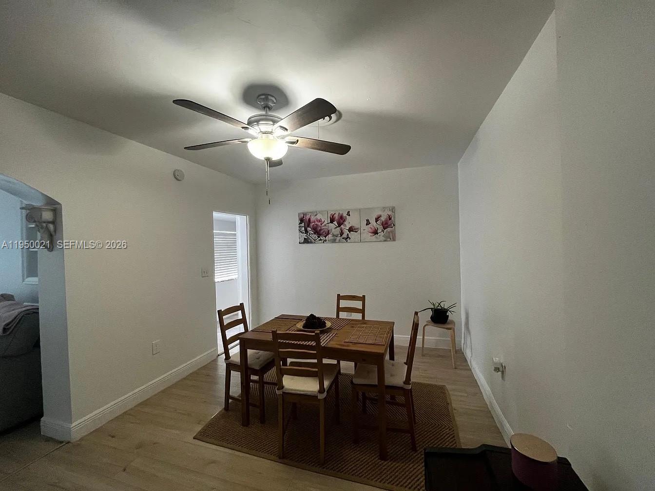 2049 Southwest 60th Court, Unit 1 Miami, FL 33155 - Photo 9 of 16 a view of a dining room with furniture and a chandelier fan