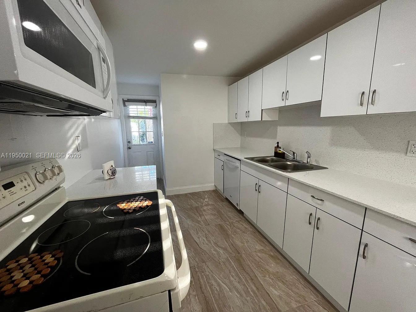 2049 Southwest 60th Court, Unit 1 Miami, FL 33155 - Photo 10 of 16 a kitchen with a stove and a sink