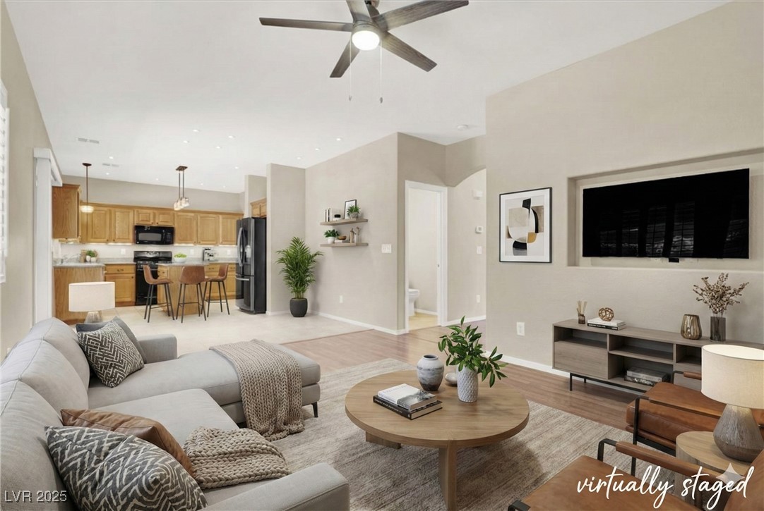 Living area featuring light wood-style flooring and a ceiling fan