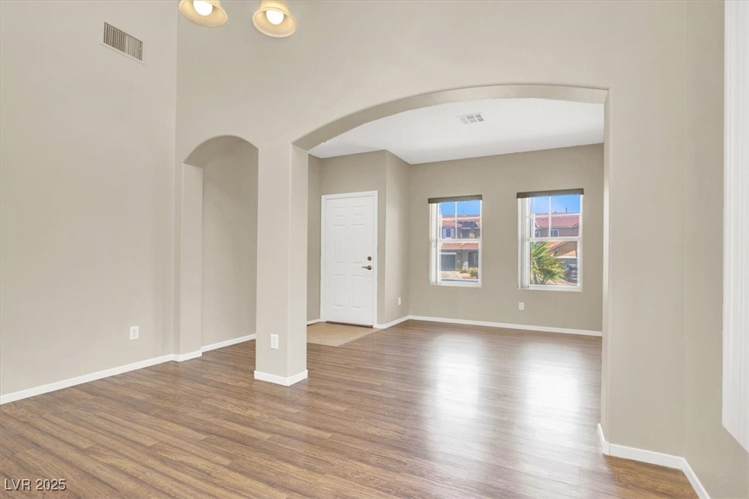 636 Pacific Cascades Drive Henderson, NV 89012 - Photo 13 of 51 Spare room featuring arched walkways and wood finished floors