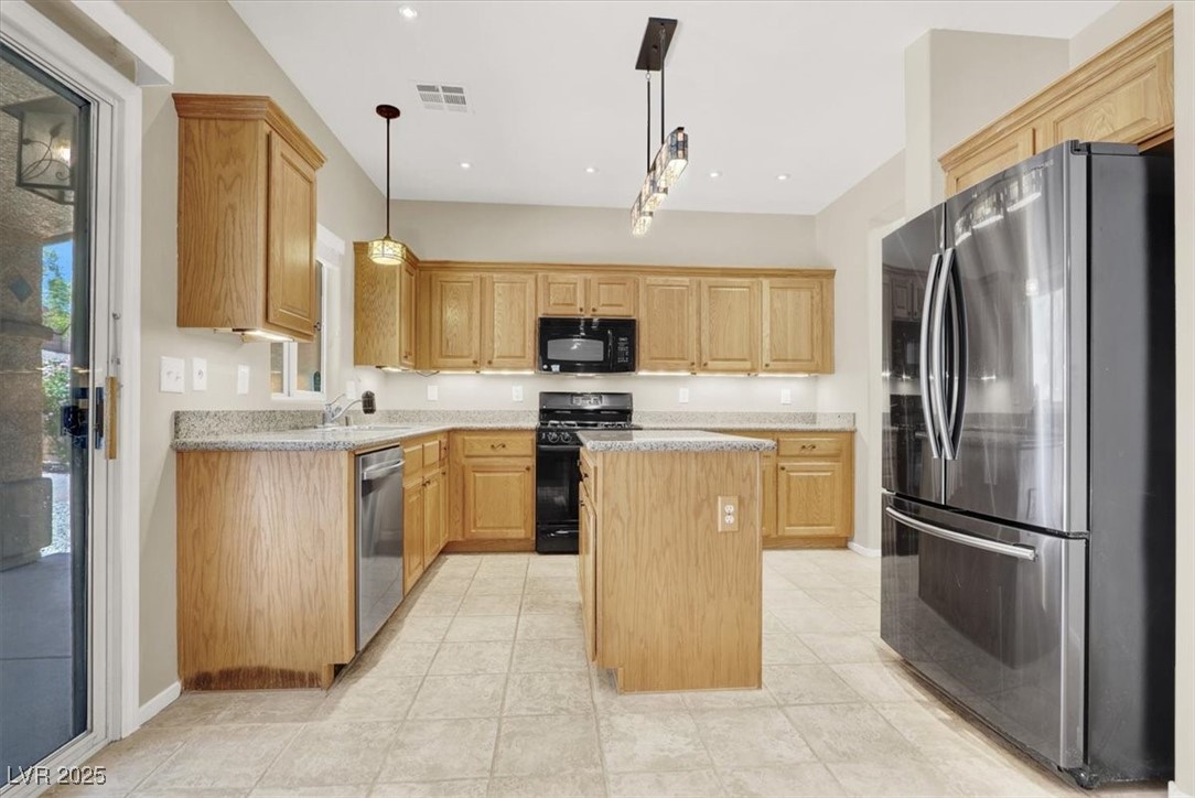 636 Pacific Cascades Drive Henderson, NV 89012 - Photo 17 of 51 Kitchen featuring black appliances, pendant lighting, a kitchen island, light stone countertops, and light tile patterned flooring