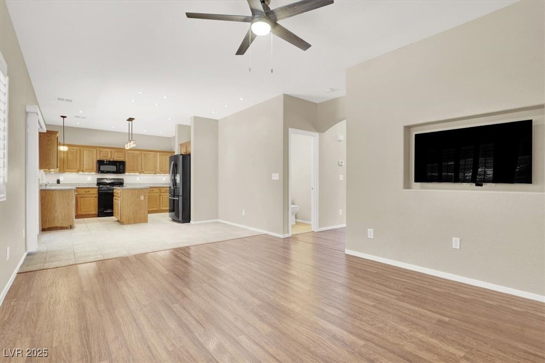 636 Pacific Cascades Drive Henderson, NV 89012 - Photo 2 of 51 Unfurnished living room with light wood-style flooring and ceiling fan