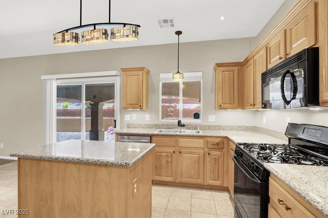 636 Pacific Cascades Drive Henderson, NV 89012 - Photo 22 of 51 Kitchen with black appliances, a center island, healthy amount of natural light, and pendant lighting