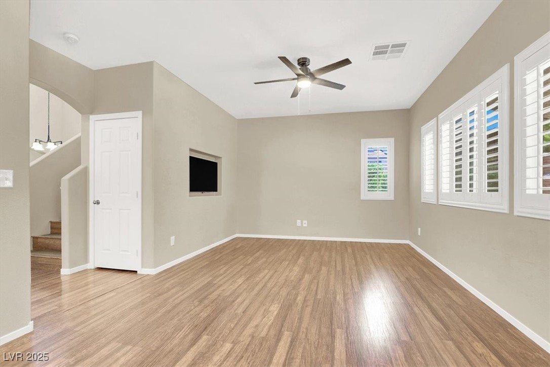 636 Pacific Cascades Drive Henderson, NV 89012 - Photo 24 of 51 Empty room featuring light wood-style floors, stairs, and a ceiling fan