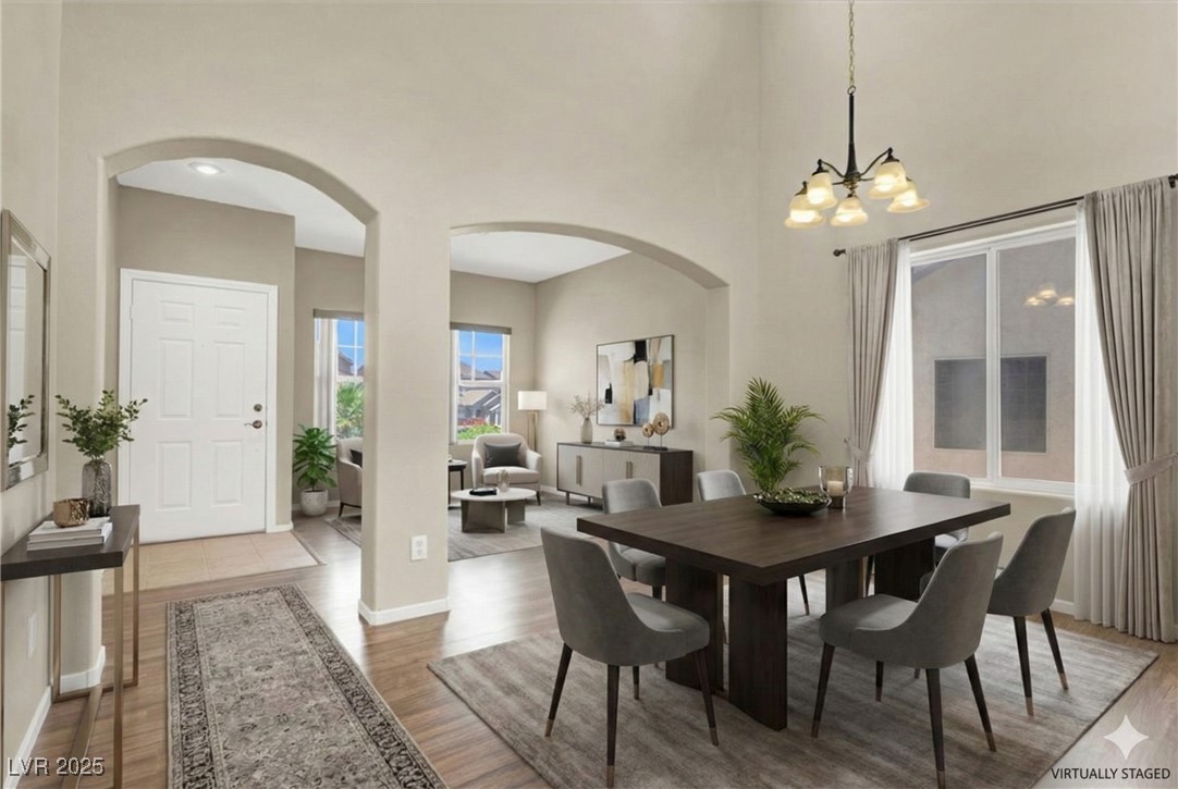 636 Pacific Cascades Drive Henderson, NV 89012 - Photo 3 of 51 Dining space featuring arched walkways, a towering ceiling, and light wood-style floors