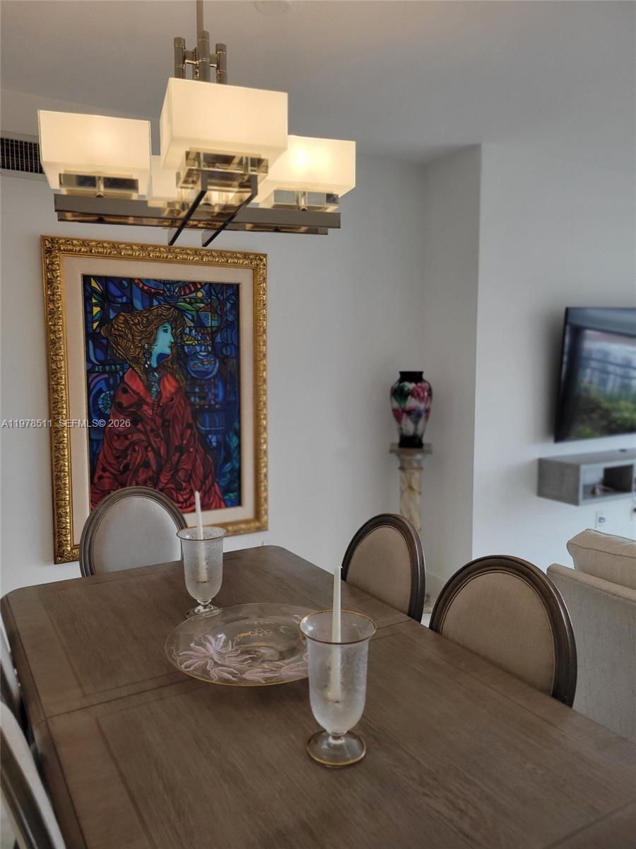 888 Douglas Road, Unit 1110 Coral Gables, FL 33134 - Photo 11 of 28 a dining table with a fireplace and wooden floor