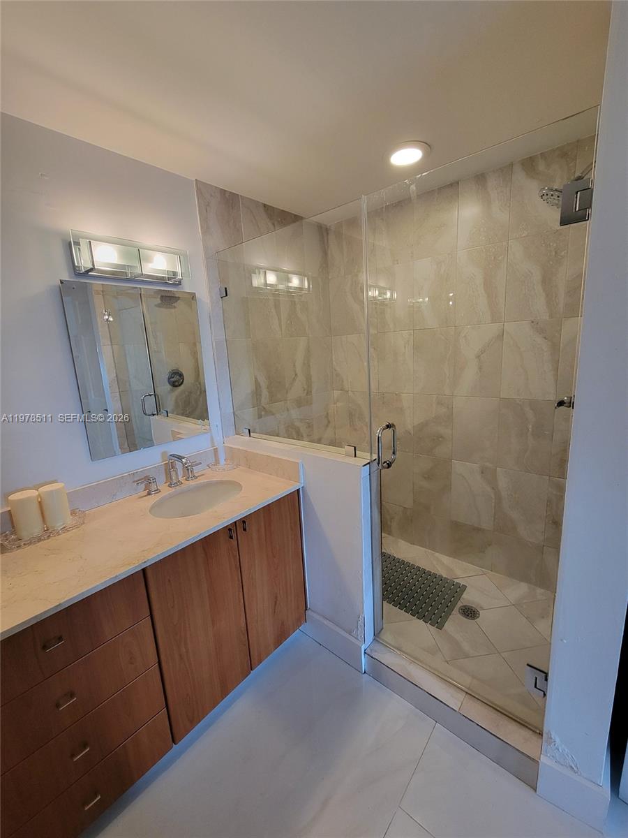 888 Douglas Road, Unit 1110 Coral Gables, FL 33134 - Photo 15 of 28 a bathroom with a shower sink and mirror