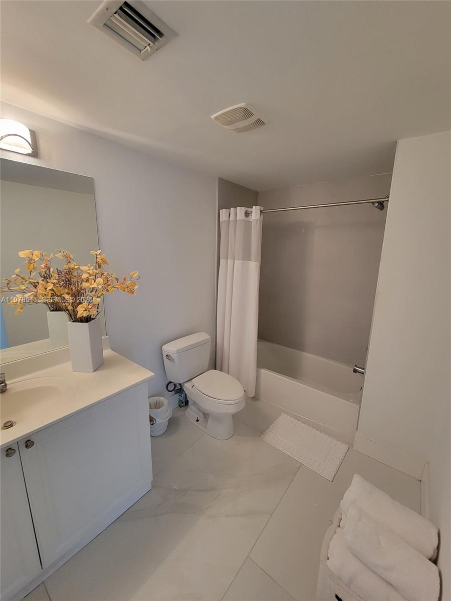 888 Douglas Road, Unit 1110 Coral Gables, FL 33134 - Photo 20 of 28 a white toilet sitting next to a bathroom sink