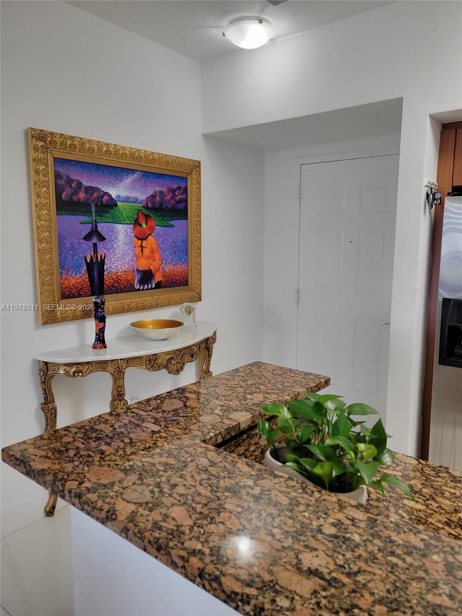 888 Douglas Road, Unit 1110 Coral Gables, FL 33134 - Photo 4 of 28 a room with painting on the wall and a potted plant