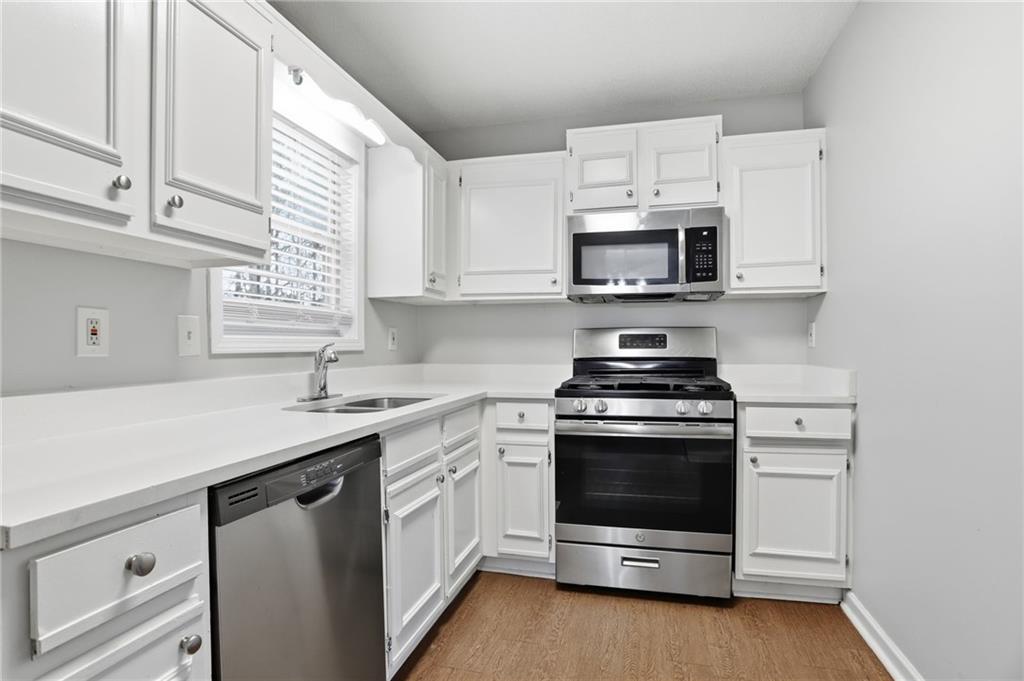 113 Hampton Drive Dallas, GA 30132 - Photo 13 of 30 a kitchen with stainless steel appliances granite countertop white cabinets a sink a stove and a microwave