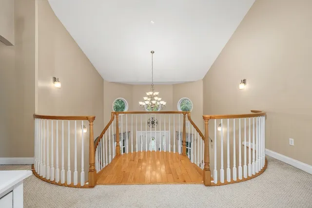 a view of staircase with railing and a chandelier