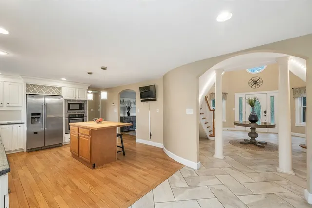 a large kitchen with kitchen island a sink table and chairs