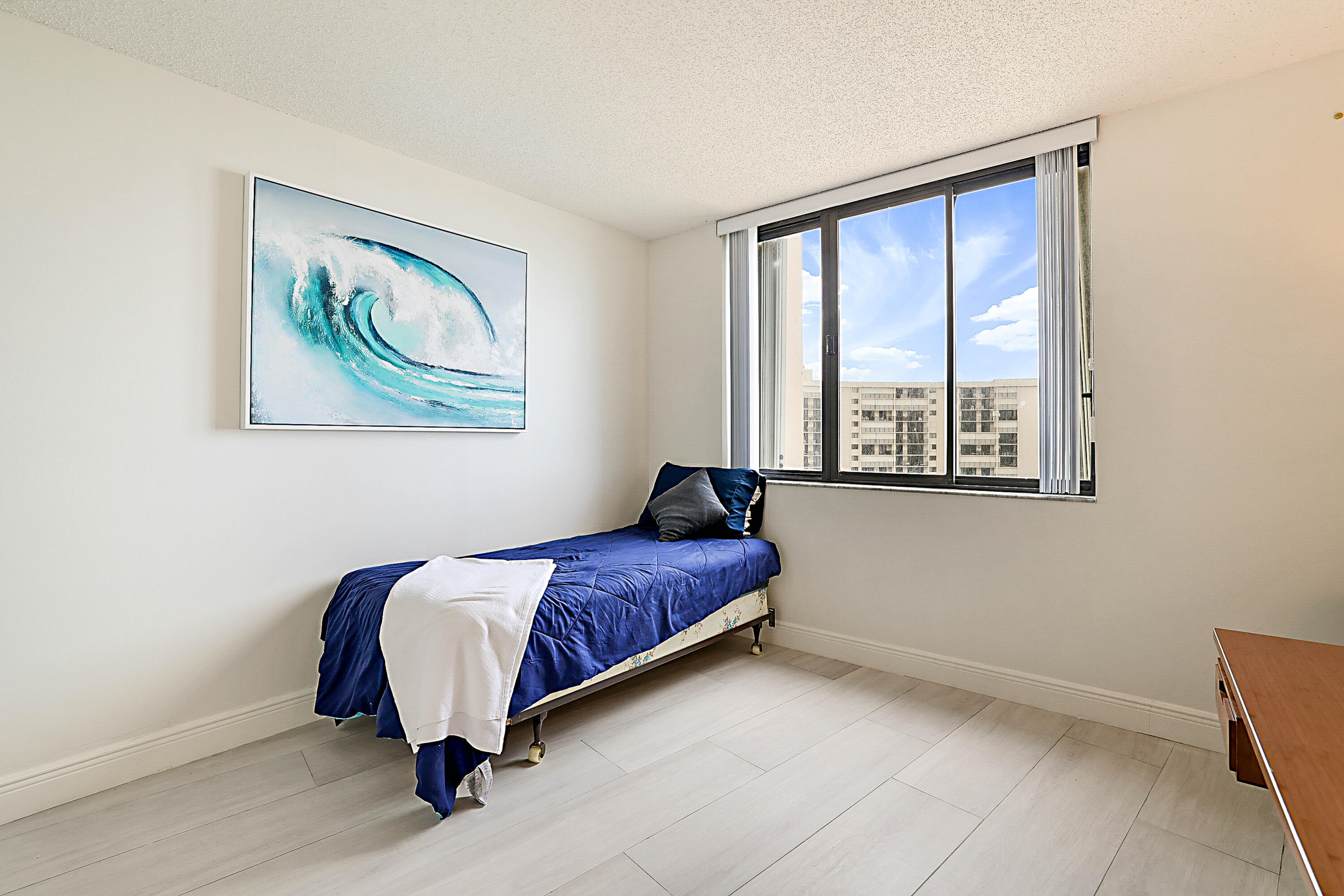 100 Ocean Trail Way, Unit 1003 Jupiter, FL 33477 - Photo 25 of 33 a bedroom with a bed and a painting on the wall