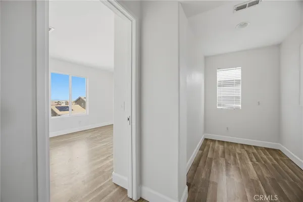 a view of room with hardwood floor and a ceiling fan
