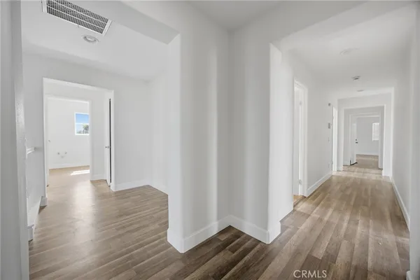 a view of a hallway with wooden floor