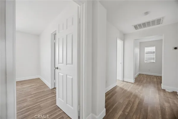 a view of a hallway with wooden floor