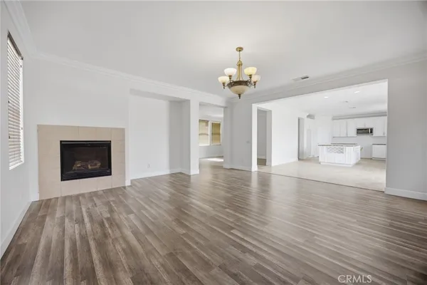 a view of a livingroom with wooden floor and a kitchen