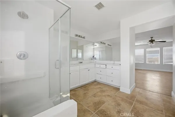a bathroom with a tub shower vanity and a sink
