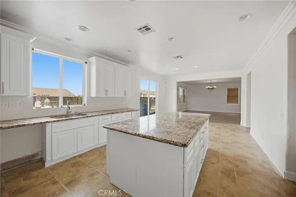a kitchen with center island granite counter tops and a sink