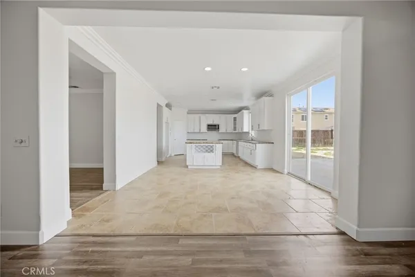 a large white room with kitchen area and windows