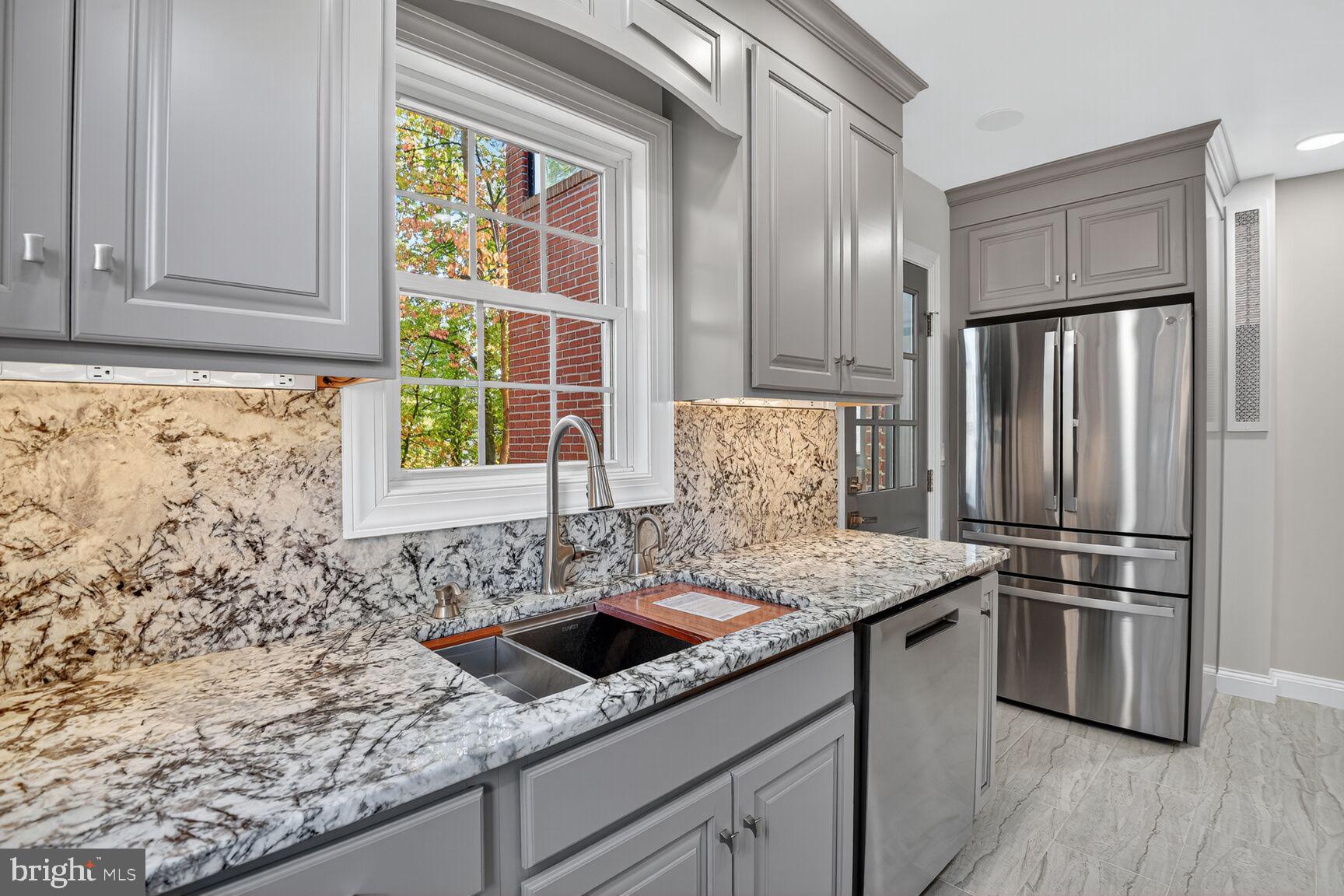 302 Penwood Road Silver Spring, MD 20901 - Photo 14 of 44 a kitchen with stainless steel appliances granite countertop a sink stove and refrigerator