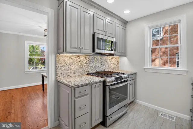 an empty room with windows and fireplace