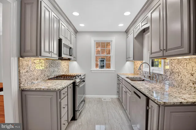 a kitchen with stainless steel appliances granite countertop a sink stove and cabinets