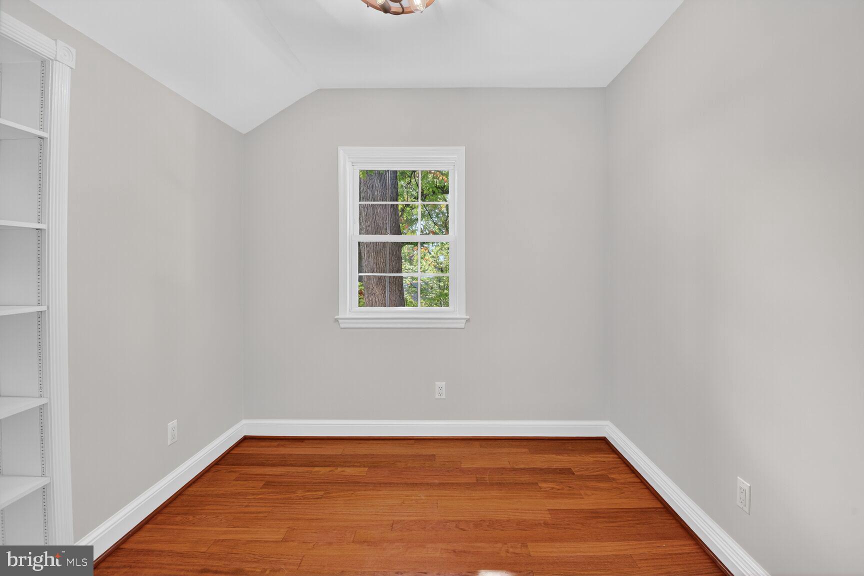 302 Penwood Road Silver Spring, MD 20901 - Photo 25 of 44 a view of an empty room with wooden floor and a window