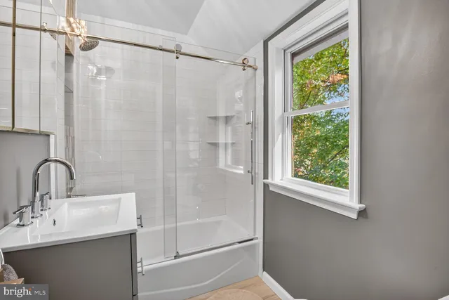 a bathroom with a sink a mirror and a shower