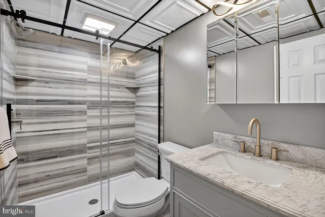 a bathroom with a granite countertop sink toilet and shower