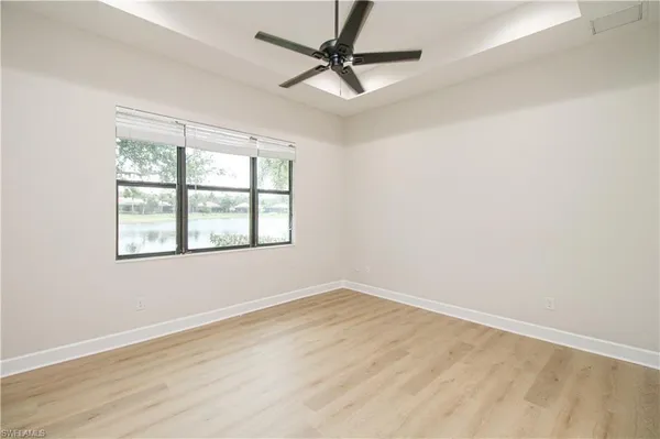 an empty room with a window and a fan