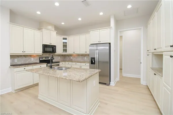 a kitchen with a refrigerator a sink and cabinets