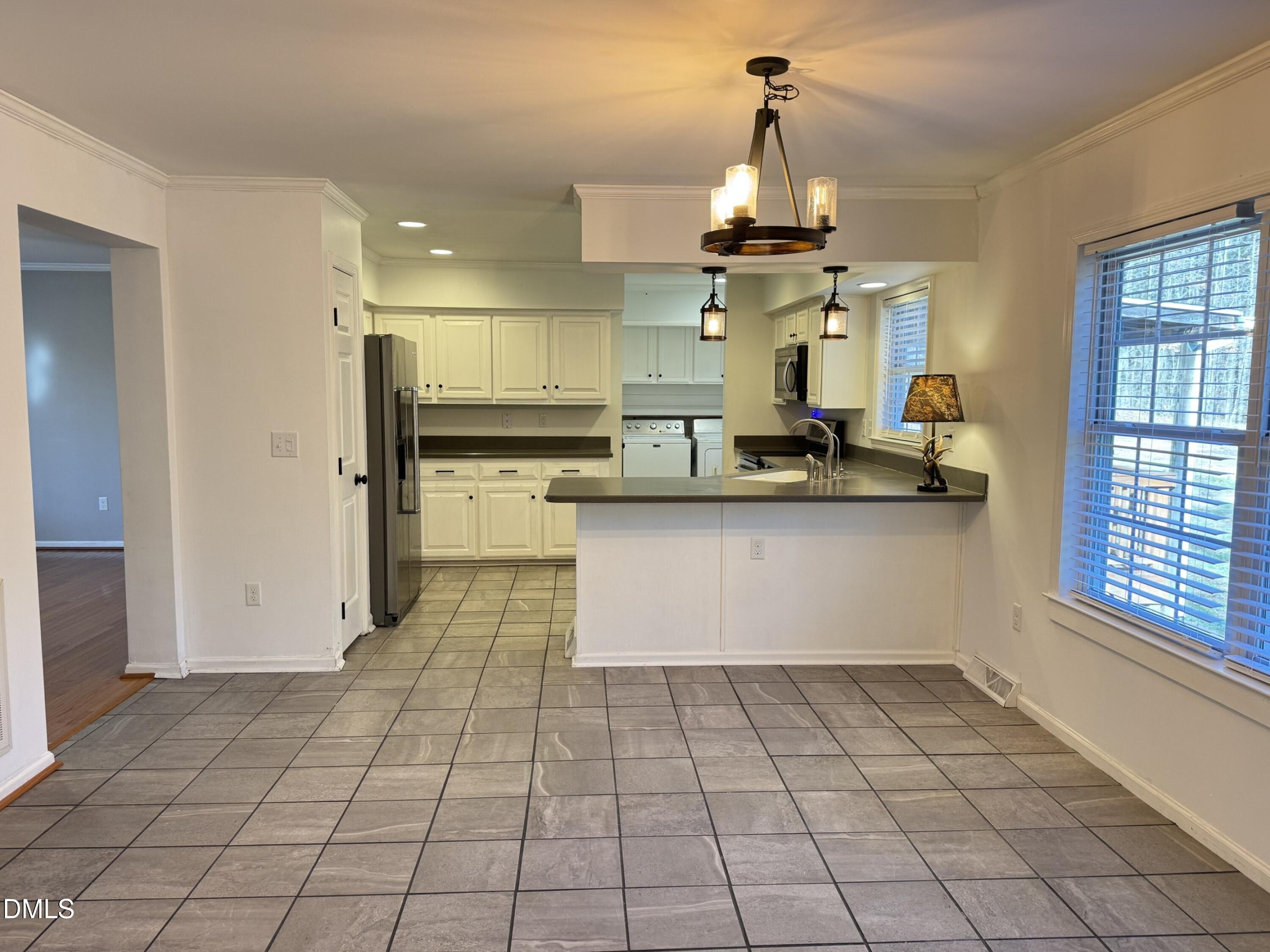 4632 Culbreth Road Oxford, NC 27565 - Photo 6 of 20 a kitchen with kitchen island granite countertop a stove a sink and a refrigerator