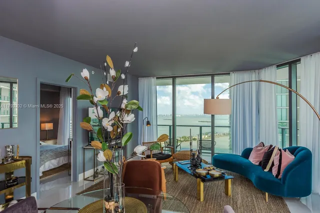 a bedroom with a bed a chair and a large window