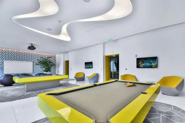 a living room with furniture pool table and couch