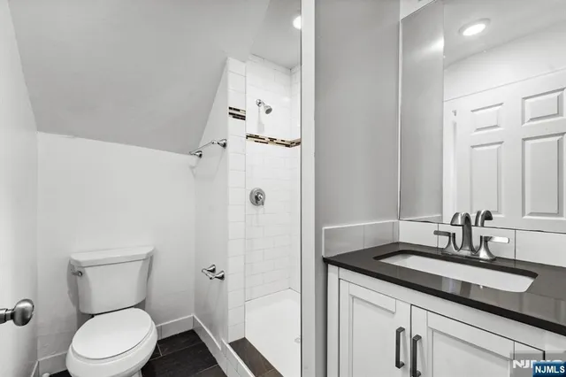 a bathroom with a granite countertop sink toilet and shower