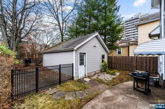 a view of a small house with wooden fence in front of it