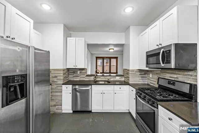 a kitchen with stainless steel appliances a sink stove and refrigerator
