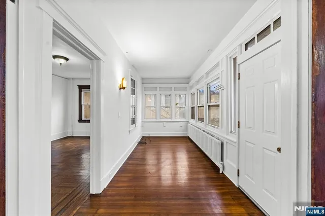 a view of a hallway with wooden floor and staircase