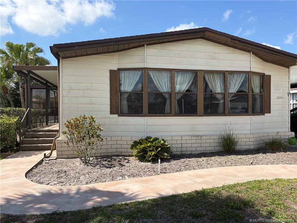 2856 Southwest Toronado Trail Stuart, FL 34997 - Photo 4 of 20 a front view of a house with a yard