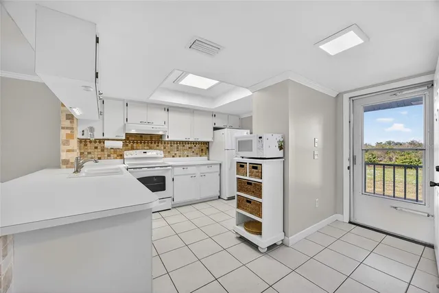 a kitchen with white cabinets and white appliances