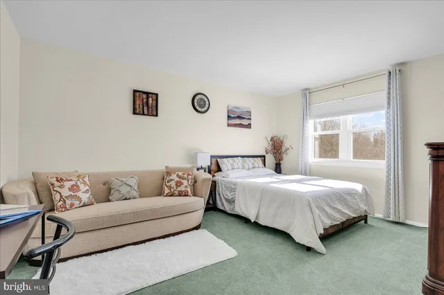 a bedroom with a bed couch and window