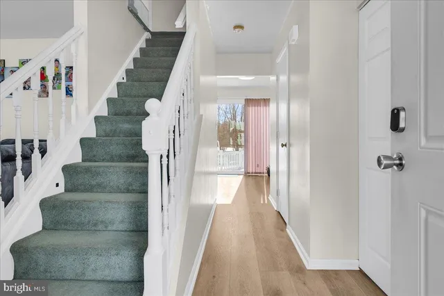 a view of entryway and hall with wooden floor