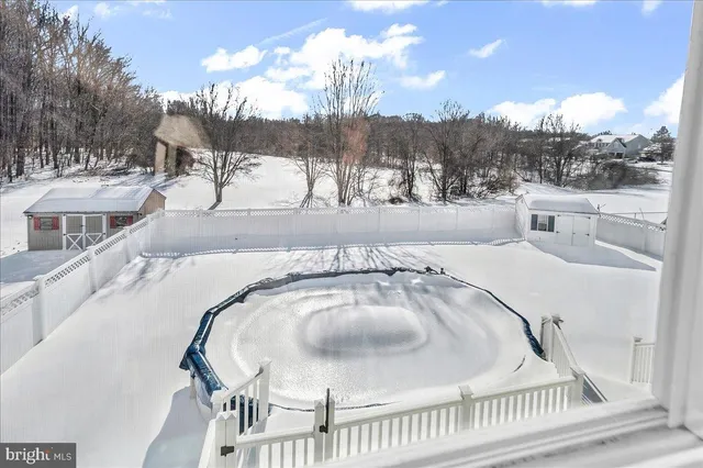 a view of a swimming pool with a patio and fire pit