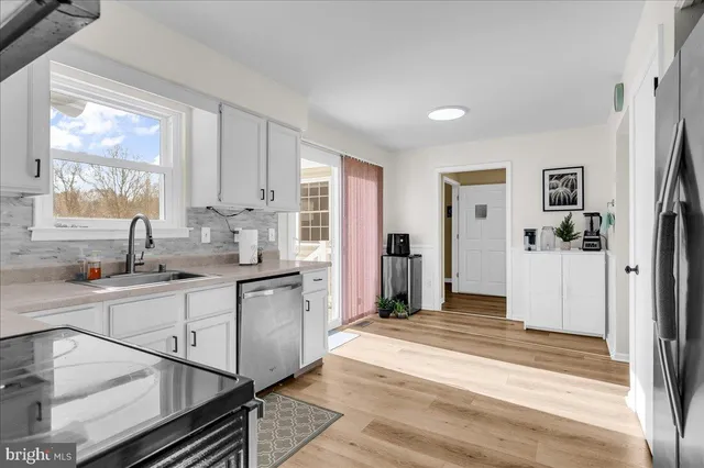 a kitchen with stainless steel appliances granite countertop a refrigerator and a sink