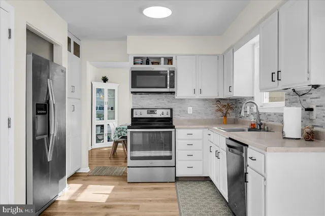 a kitchen with stainless steel appliances granite countertop a refrigerator and a stove top oven
