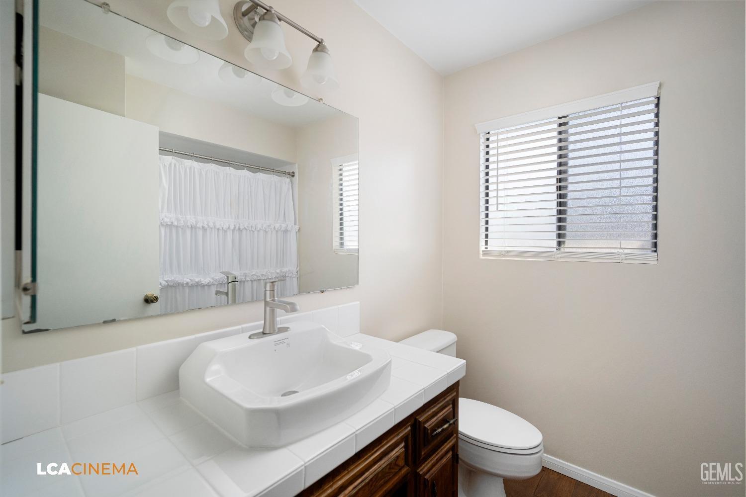 Undisclosed Address Bakersfield, CA 93309 - Photo 15 of 22 a bathroom with a sink a toilet and a window