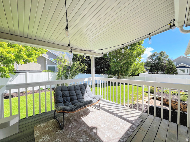 12169 Hidden Valley Road, Unit 44 Sandy, UT 84092 - Photo 37 of 49 Covered deck with a slatted ceiling, string lighting, and white railings